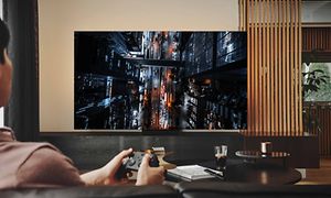 En gut spiller videospill på Samsung Neo QLED Gaming TV med lav input lag