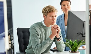 B2B - To kolleger på et kontor foran en PC 1000x500