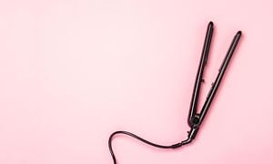 Hair straightener on a pink background