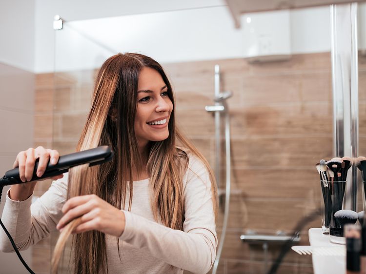 Woman using hair straightener