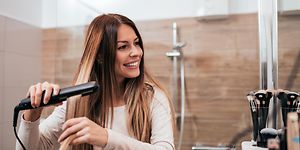 Woman using hair straightener