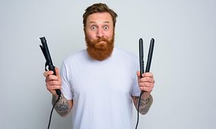 Man with hair straightener and curling iron