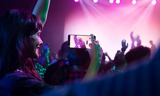 Kvinne på en konsert som filmer en sanger på Google Pixel 7 Pro