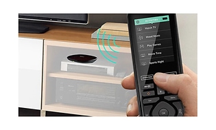 Logitech-Han holding remote in front of TV