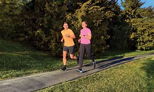 En mann og kvinne som løper med Garmin Forerunner sportsklokke på armene deres