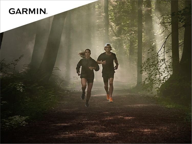 En kvinne og en mann som løper i skogen med Garmin forerunner smartklokke på armen