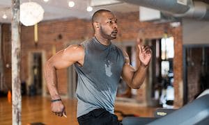 Man running with in-ears in gym