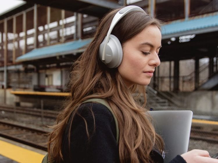 Woman with headphones on train station