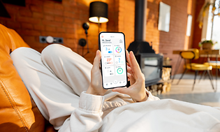 Person i koseklær som får oversikt over strømforbruket på telefonen med Futurehome-appen