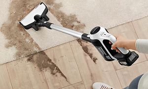 Bosch Unlimited-støvsuger serie 6 med et Bosch AllFloor-munnstykke som renser smuss fra et teppe