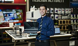 Elkjøp-selger i butikk holder en chrombook