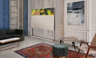 LG OLED TV med det staffeli-inspirerte designet står i en kunstnerisk stue inntil en vegg med 