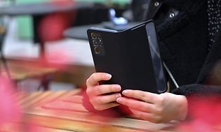 Telecom - Change Android old to new . A person holding a phone against a table