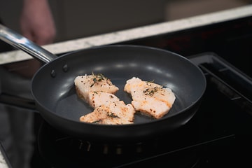Fish being fried on a frying pan