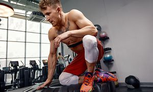 Telecom - Workout - man sitting on tire with heart rate monitor on