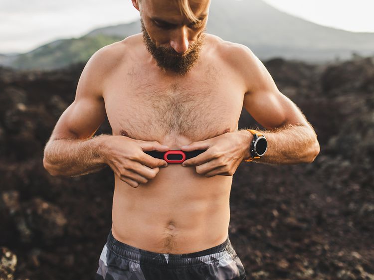 A man attaching a heart rate monitor to his chest