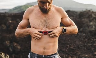 A man attaching a heart rate monitor to his chest
