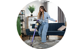 A girl vacuums a room with headphones on