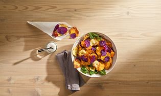 Stekt grønnsakschips og salt på et bord sett ovenfra