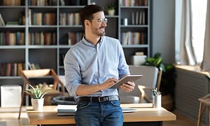 B2B - CS - Services - A smiling man with a tablet in an office