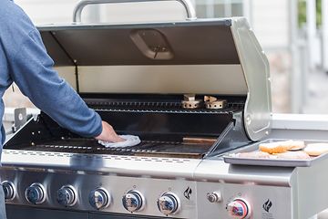 Man cleaning grill