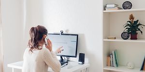 Kvinne på hjemmekontor foran PC med eksternt webkamera