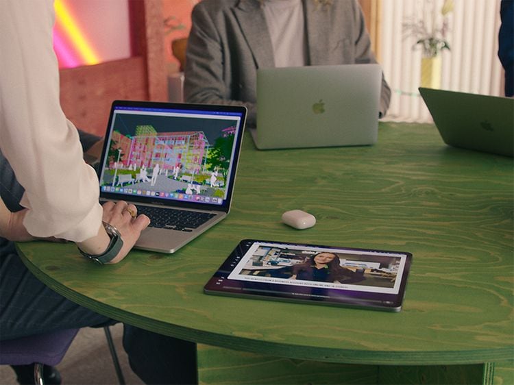 Grønt bord med MacBook, iPad og Airpods