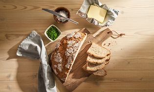 Ferskt surdeigsbrød servert på et bord med smør sett ovenfra