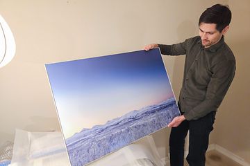 Elkjøp-kunde Jonas Karlsen holder opp et print av et bilde tatt med  Samsung Galaxy S23 Ultra