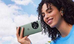En grønn OnePlus 11 5G-smartteleon i hånda på en kvinne 