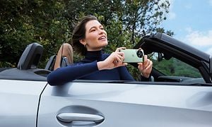 Kvinne i bil med OnePlus 5G med 3. generasjons Hasselblad-mobilkamera