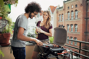 couple grilling on balcony