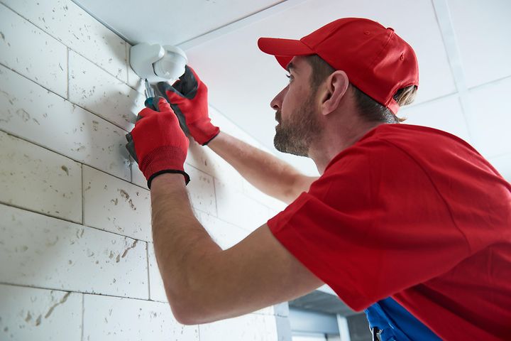 Man installing motion sensor on wall