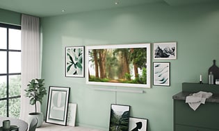 Samsung The Frame med skogmotiv på skjermen veggfestet i en grønn stue