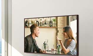 Samsung The Frame TV som henger på vegg og viser mann og kvinne