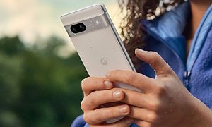 Kvinne holder en Google Pixel 7a i regnet