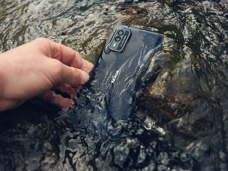 Vanntett NokiaXR21-telefon blir plukket opp fra vann