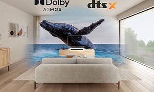 En stue med TV og Sony HT-S2000 lydplanke med Dolby Atmos og en hval kommer ut av TV-en