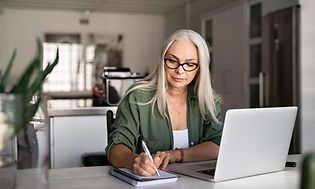 En dame som sitter å jobber på PC-en