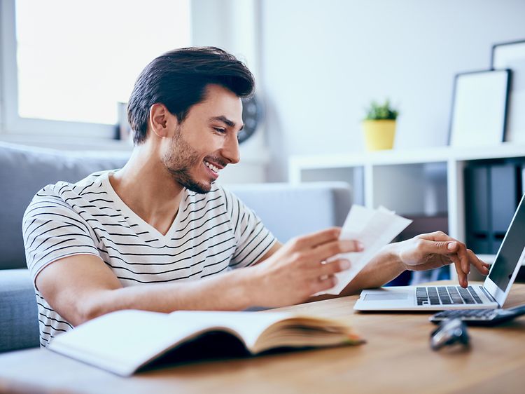 En mann som betaler regninger på PC-en