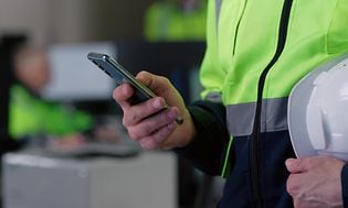Guide robuste mobiler - Smarttelefon i hånden på arbeider på byggeplass
