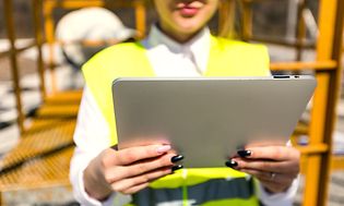 B2B - Tech Gadget - Female construction worker checking her tablet at the construction site