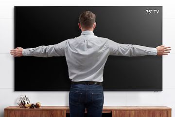 Samsung 75" TV som måles av mann