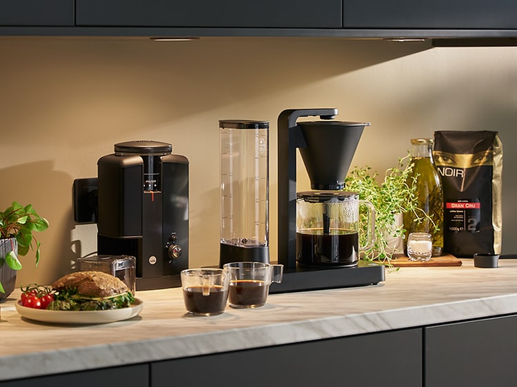Wilfa - SDA - Kaffetrakter, kaffeutstyr og kaffekopper på et bord - 1600x600