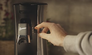 Nærbilde på en hånd som justerer kaffeintensiteten på en Senseo Select kaffemaskin