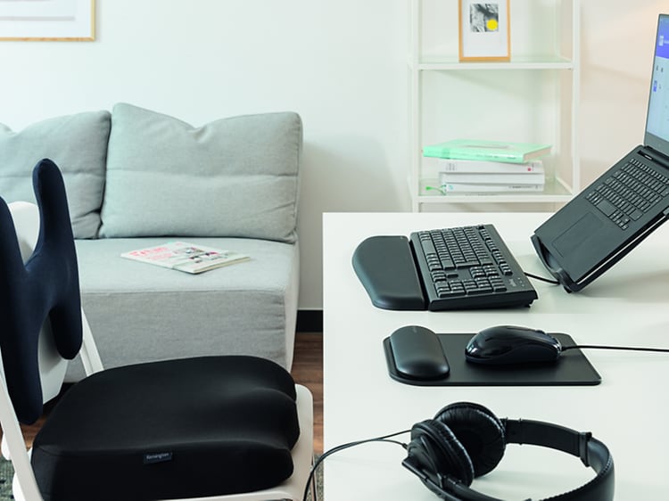 Hjemmekontor med bærbar PC i stativ, eksternt tastatur, trådløs mus og hodetelefoner