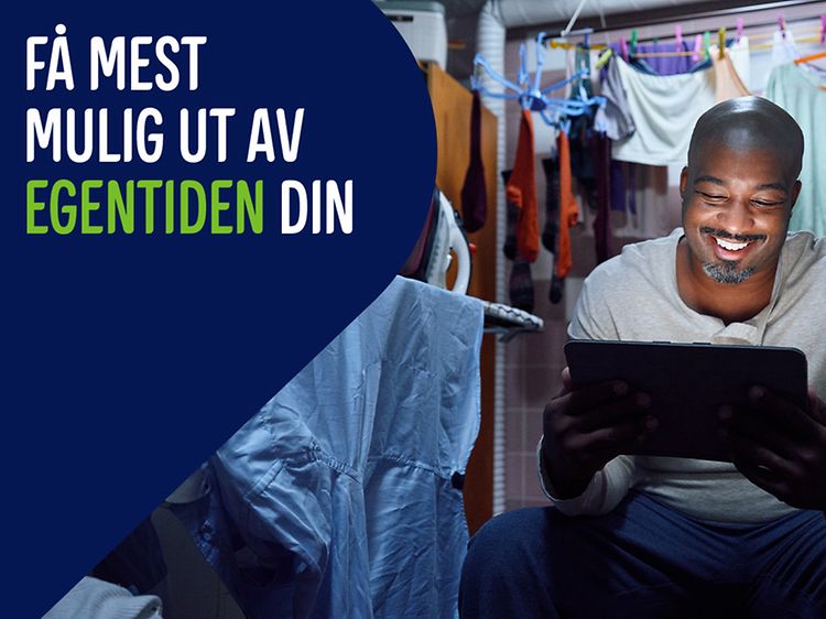 Man has escaped to a laundry room with his tablet. Banner text: Få mest mulig ut av egentiden din