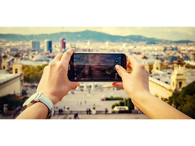 Kvinne tar feriebilder med smarttelefon med beskyttelsesdeksel