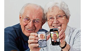 Eldre par med smarttelefon med bilde av hverandre