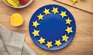 Blå tallerken på bord med skåret stjernefrukt i en sirkel langs kanten illustrerer EU-flagget